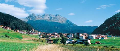A rural village with houses and a mountain in the background.
