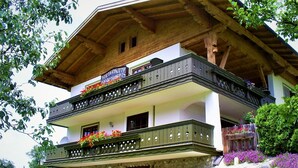 A two-story building with a wooden balcony and flower boxes. - Gsenger in Abtenau by Interhome (Abtenau)