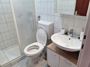 A bathroom with a toilet, a sink, and a shower. - in Baška mit Terrasse by Interhome (Krk/Baška)