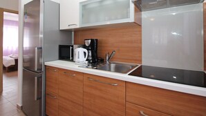 A modern kitchen with stainless steel appliances, wooden cabinets, and a built-in microwave. - Appartement in Baška mit Terrasse by Interhome (Krk/Baška)