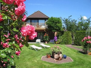 A house with a balcony, a garden with a lawn, and a cat statue. - Langeiig by Interhome (Wiesmoor)