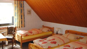 A cozy attic bedroom with two wooden beds, a desk, and a chair. - Wohnung in Goosefeld mit Grill by Interhome (Eckernförde)