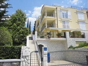 A multi-story building with balconies, a stone facade, and a gated entrance. - mit Blick auf das Wasser by Interhome (Crikvenica)