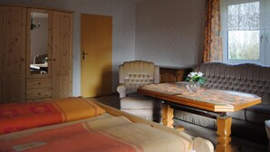 Una camera da letto con un letto, una sedia, un tavolo e una finestra.