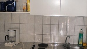 Eine kompakte Küche mit integriertem Kühlschrank, Spüle und Herd.
