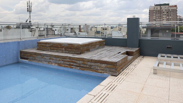 A rooftop pool with a wooden deck and a blue-tiled pool area. - Modern Studio Apartment Full Amenities in Palermo (Buenos Aires)