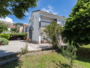 A modern two-story house with a balcony, surrounded by greenery and a clear sky. - Charmantes Appartement in Baška mit Eigenem Balkon by Interhome (Krk/Baška)