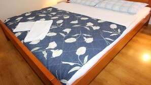 A neatly made bed with a floral bedspread, white pillows, and a white towel on the side. - Appartement in Baška mit Eigenem Balkon by Interhome (Krk/Baška)