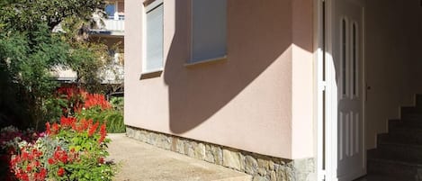 Un bâtiment avec un chemin de pierre menant à une porte blanche.