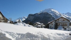 A snow-covered mountain landscape with a chalet-style building in the foreground. - Chesa Ovelin by Interhome (Pontresina)