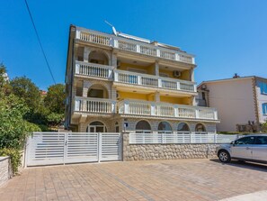 A multi-story building with balconies, a gated entrance, and a parked car. - Wohnung für 6 Personen mit Balkon und Meerblick by Interhome (Crikvenica)