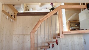 En træt trappe med gelænder i træ og en glasdør øverst.