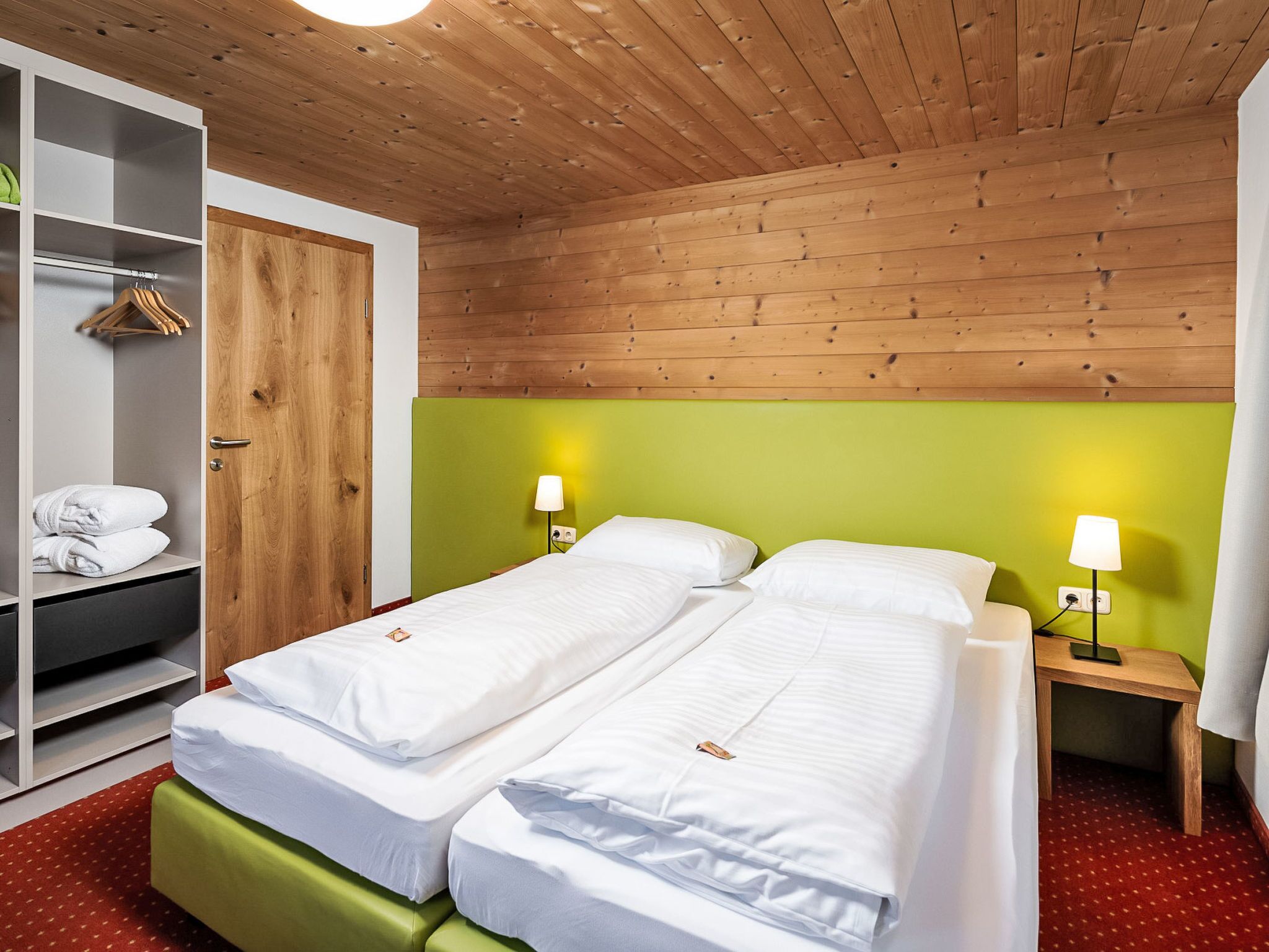 Een hotelkamer met twee bedden, een kledingkast en een badkamer.