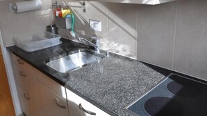 Eine Küche mit Granit Arbeitsplatte, Spüle aus Edelstahl und einem Geschirrspüler von ZUG.