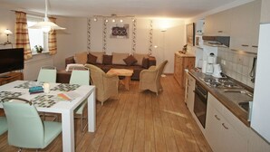 Een knus woongedeelte met een eethoek, een bank en een kitchenette.