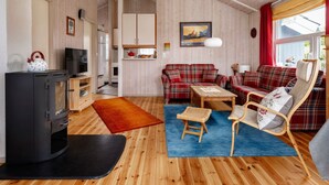 A cozy living room with a fireplace, a sofa set, a wooden coffee table, and a TV. - Dänemark in Gelting by Interhome (Gelting)
