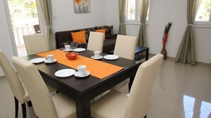 Een eetgedeelte met een tafel voor vier personen, een bank en een decoratieve vaas.