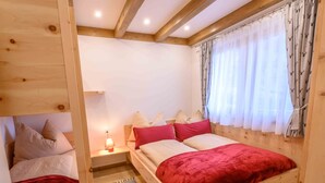Une chambre à coucher avec un cadre en bois, comprenant un lit, des tables de chevet et une fenêtre avec des rideaux.