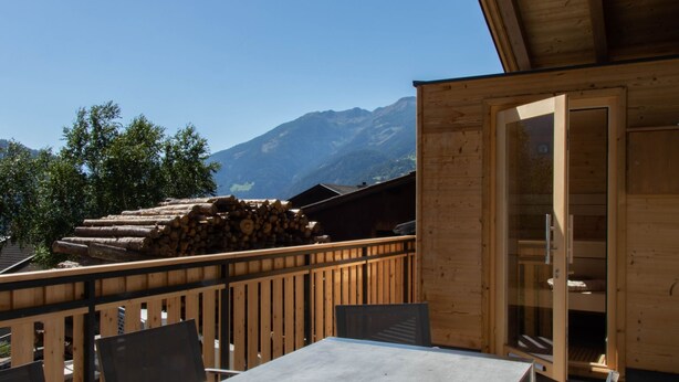 Une cabane en bois dotée d’un balcon donnant sur une montagne.