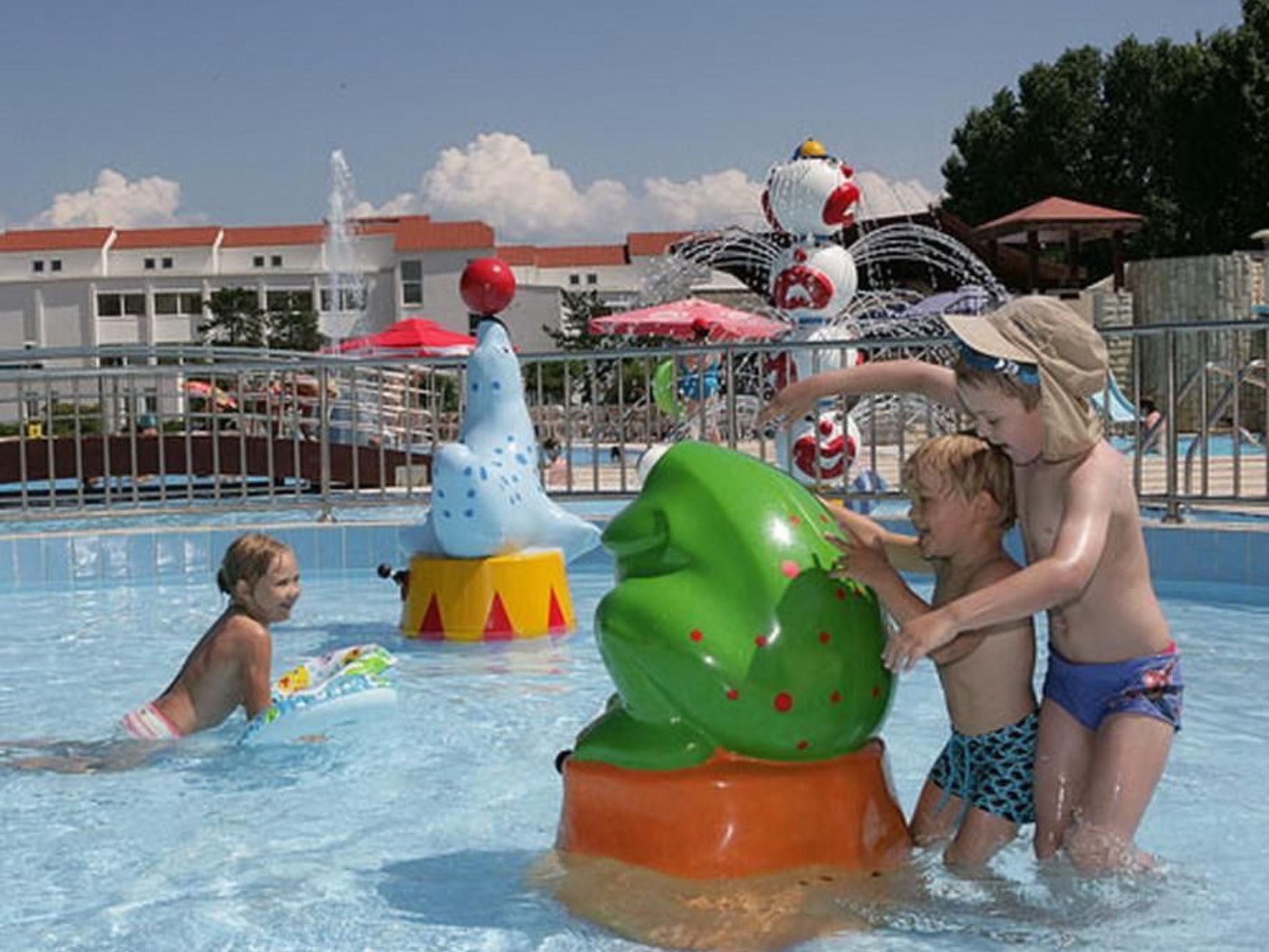 Une piscine avec des toboggans et des jeux gonflables.