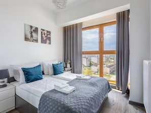 A modern hotel room with a large bed, a nightstand, a lamp, and a view of the city through a large window. - Tower 97 in hervorragender Lage by Interhome (Swinoujscie)