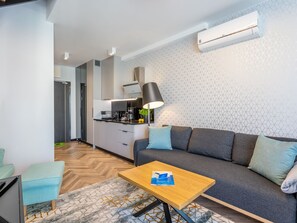 Un soggiorno moderno con un divano grigio, un tavolino in legno e un tappeto decorato.