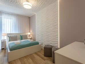 A modern bedroom with a bed, bedside tables, and a unique textured wall. - Ostsee-Ferienwohnung Bianco 8 mit Kamin by Interhome (Swinoujscie)