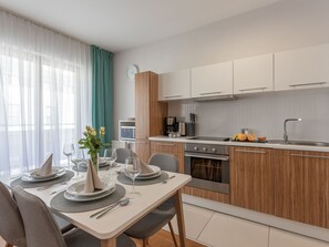 A modern kitchen with wooden cabinets, a built-in oven, and a stainless steel sink. - Ferienappartement Platan 1 auf Usedom by Interhome (Swinoujscie)