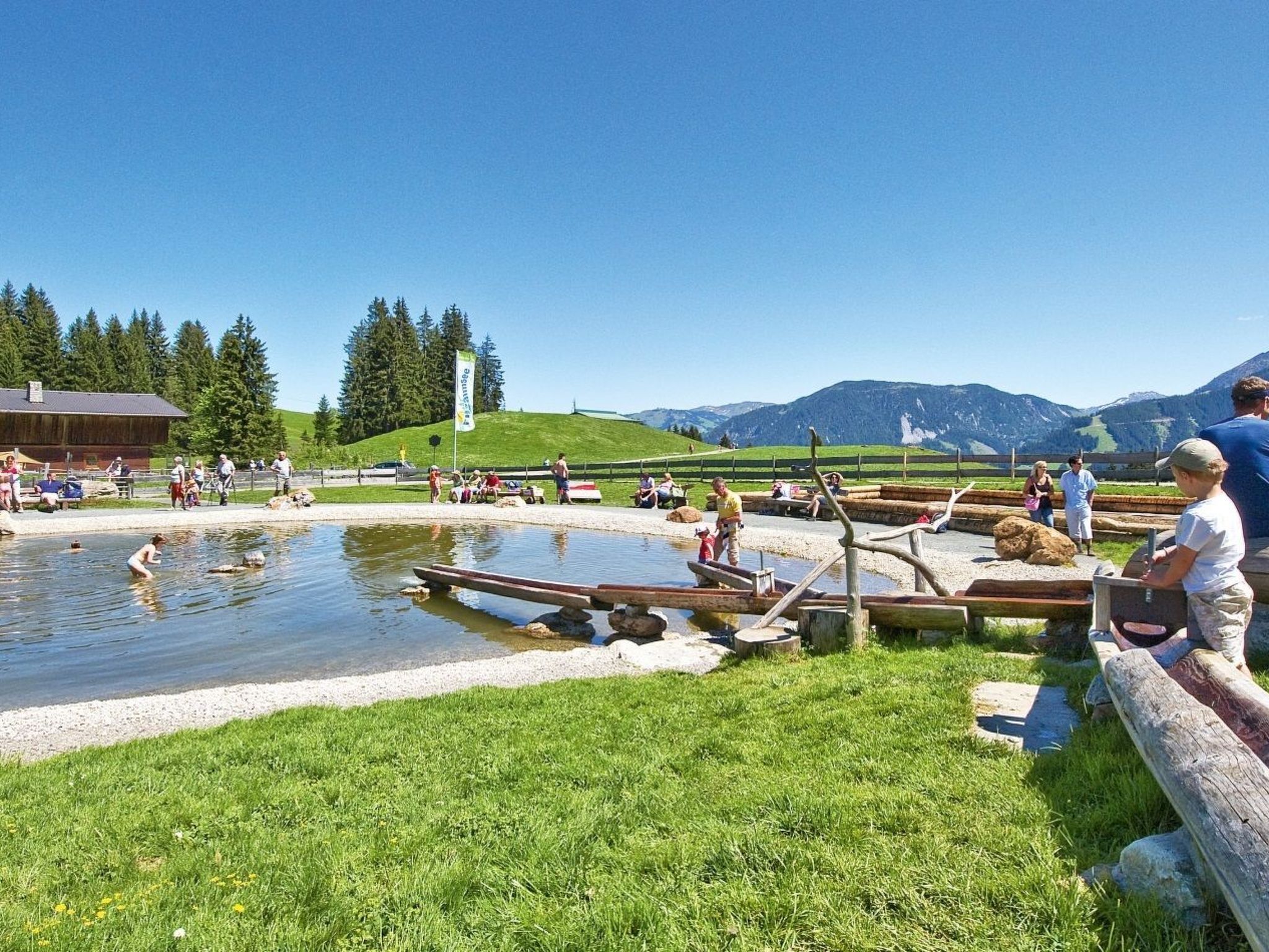 A natural hot spring area with people relaxing and swimming.