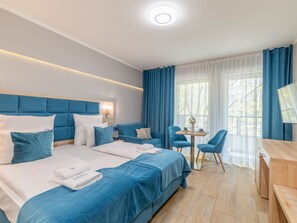 Een hotelkamer met een groot bed, een bank, een bureau en een kleine tafel.