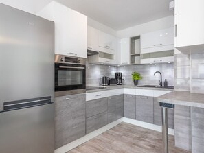 Eine moderne Küche mit Backofen, Kaffeemaschine und Spüle.