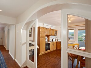 Eine moderne Küche mit Holzschränken, einem eingebauten Ofen und einem Fenster mit Blick auf eine reizvolle Landschaft.