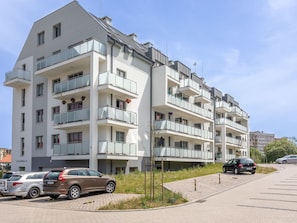 A multi-story residential building with balconies, parked cars, and a clear sky. - Geräumiges Ferienappartement Bianco 31 by Interhome (Swinoujscie)