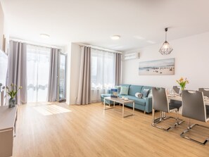 Ein modernes Wohnzimmer mit Sofa, Couchtisch und Essbereich.