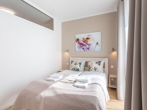 Ein modernes Schlafzimmer mit einem Bett, einem Gemälde und einem Nachttisch.