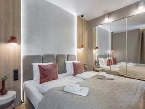 A modern hotel room with a large bed, a bedside table, a mirror, and a wall with a subtle pattern. - Appartement Jachtowa direkt am Hafen von Usedom by Interhome (Swinoujscie)