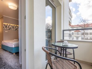 A hotel room with a bed, a small table with chairs, a window with a view of buildings, and a ceiling light. - in einzigartiger Lage auf Usedom by Interhome (Swinoujscie)