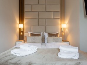 A hotel room with a large bed, two bedside tables, and two wall-mounted lamps. - Rose 1 in Swinemünde am Meer by Interhome (Swinoujscie)
