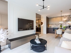 A modern living room with a large flat-screen TV, a black coffee table, and a sofa. - Ruhige Ferienwohnung am Meer by Interhome (Swinoujscie)