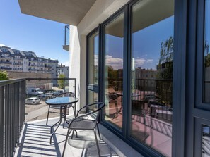 A balcony with a glass door, a table, and two chairs. - Zentrum an der Ostsee by Interhome (Swinoujscie)