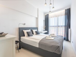 A modern hotel room with a large bed, bedside tables, a desk, and a window with curtains. - Helle Ferienwohnung Tower 76 auf Usedom by Interhome (Swinoujscie)