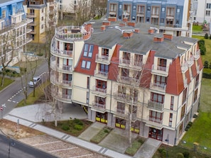 A multi-story residential building with balconies, a central courtyard, and a parking area. - Urlaub auf Usedom, Apartment Wind Rose 33 by Interhome (Swinoujscie)
