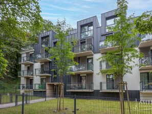 A modern apartment building with multiple balconies, a fenced courtyard, and surrounding greenery. - am Meer, Urlaub auf der Insel Usedom, Apartment Matejki 27 by Interhome (Swinoujscie)