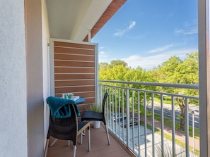 A balcony with a view of a green landscape, a table with chairs, and a potted plant. - Tower 22 in ruhigem Stadtviertel by Interhome (Swinoujscie)