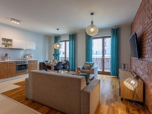 Eine moderne Wohnung mit Küche, Essbereich, Wohnzimmer und Balkon.