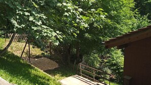 Une cabane en bois avec un escalier en béton menant à une rambarde en métal.
