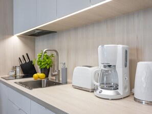 Eine moderne Küche mit integriertem Spülbecken, einer Kaffeemaschine und einem Toaster.