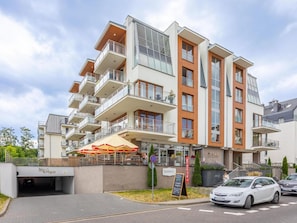 Ein mehrstöckiges Hotel mit Balkonen, einem Restaurant namens PEGAZ und einem Parkbereich.