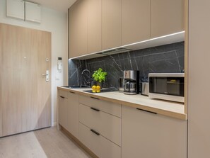 A modern kitchen with a black marble backsplash, a coffee maker, and a microwave. - Matejki 2 - Ihr Zuhause in der Ferne by Interhome (Swinoujscie)