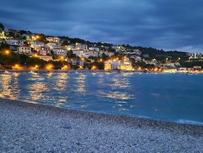 A coastal town at dusk with buildings along the shoreline. - Villa Destiny by Interhome (Nedescina)